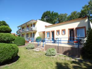 a house with a balcony and bushes in front of it at OW Światowid in Dźwirzyno