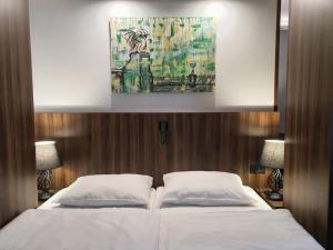 a bedroom with a large bed with two white pillows at Atelier Hotel in Ljubljana