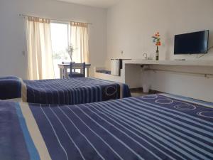 a hotel room with two beds and a television at Luna Azul in Tapachula