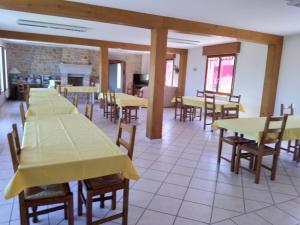 a dining room with yellow tables and wooden chairs at Vent des Grèves in Pontorson