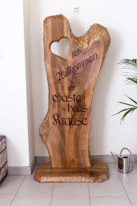 a heart shaped wooden sign on a wall at Gästehaus Krause in Trumau