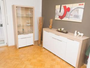 a kitchen with white cabinets and a wooden floor at Ferienwohnung Lemke in Donaueschingen