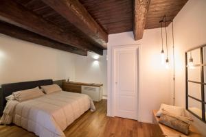 a bedroom with a white bed and a wooden ceiling at Corte Capomazza Appartamenti in Naples