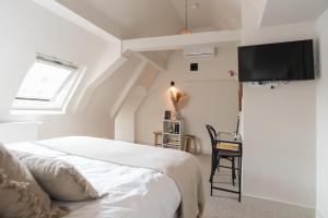 een slaapkamer met een bed en een tv aan de muur bij Empire suites garden view in Amsterdam