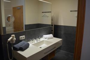 a bathroom with a white sink and a mirror at Hotel Garni Frommes in Fiss