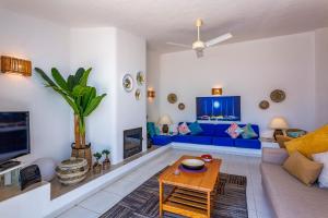 uma sala de estar com um sofá azul e uma televisão em Villa in Quinta da Balaia em Albufeira