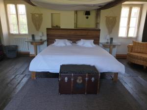 Un dormitorio con una cama grande con un baúl. en Gite La Grange de Jeanne en Rancon