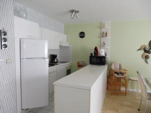 a kitchen with a white refrigerator and a table at Gabbiano De witte meeuw in Koksijde