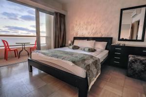 a bedroom with a bed and a table and a window at Hotel Blue Weiss in Netanya