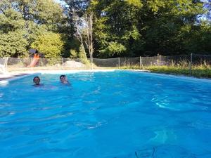 twee personen zwemmen in een blauw zwembad bij Camp Wild West in Höör