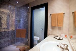 a bathroom with a sink and a shower and a toilet at Hotel Riu Nautilus - Adults Only in Torremolinos