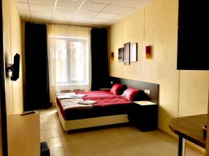 ルーガにあるHotel Globusのベッドルーム1室(赤いシーツ付きのベッド1台、窓付)