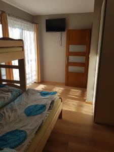 奧考特尼查古爾納的住宿－Na Zakręcie，一间卧室设有双层床、窗户和门。