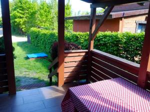 a balcony with a table and a view of a yard at Gowidlino - Domek Letniskowy nad Jeziorem in Gowidlino