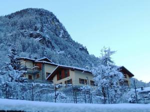 a house covered in snow in front of a mountain at La vista sulla Valmalenco in Lanzada