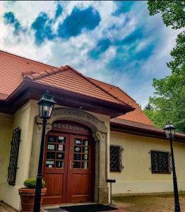 a house with a wooden door and a red roof at Malá Svatá Hora - penzion & restaurace in Mníšek pod Brdy