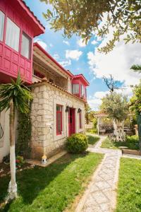 una casa con una puerta roja y un patio en Aişem By Hire en Alacati