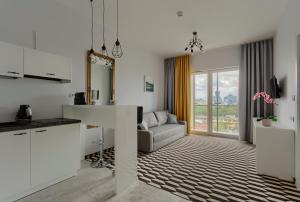 kuchnia i salon z kanapą i stołem w obiekcie Apartamenty Prymasa Residence w Warszawie