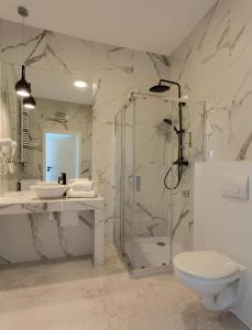 a bathroom with a shower and a toilet and a sink at Apartamenty Prymasa Residence in Warsaw