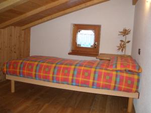 Una cama con una manta colorida en una habitación en Chalet Mas del Toni, en Rabbi
