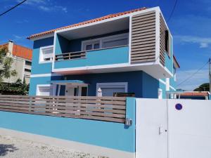 a blue and white house with a fence at Lisbon Beach Apartments 4 in Costa da Caparica
