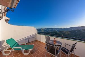 Un balcón con sillas y una mesa con vistas. en Apartamentos Rosamarina en Frigiliana