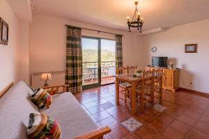 Una sala de estar con un sofá, una mesa y sillas. en Rosamarina, en Frigiliana