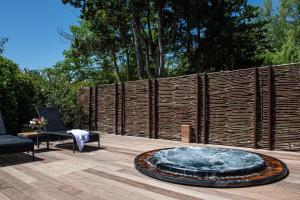 een patio met een vuurplaats en een houten hek bij Hôtel Mas Valentine in Saint-Rémy-de-Provence