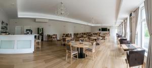 ein Esszimmer mit Tischen und Stühlen und einem Kronleuchter in der Unterkunft AM Hotel Kaštieľ & Restaurant in Rimavská Sobota