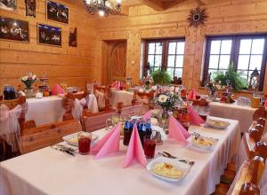 uma sala de jantar com mesas brancas e guardanapos cor-de-rosa em Przystań w Rzepiskach em Rzepiska