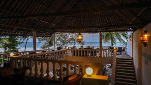 a dining room area with a balcony and a balcony view at Papillon Lagoon Reef Hotel in Diani Beach