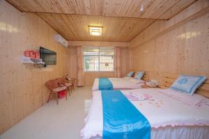 two beds in a room with wooden walls at Nanjing Yunshuiyao Haixi Inn Dashuiche in Nanjing