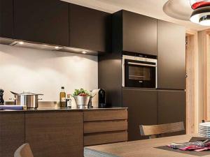 a kitchen with black cabinets and a counter top at Apartment Turrabuel 4-Bett Deluxe by Interhome in Parpan