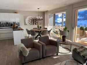 kuchnia i salon ze stołem i krzesłami w obiekcie Apartment Alpenrose by Interhome w mieście Adelboden