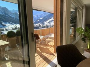 a door to a balcony with a view of the mountains at Apartment Alpenrose by Interhome in Adelboden
