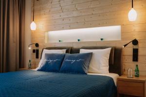 - une chambre avec un lit doté d'oreillers bleus et blancs dans l'établissement Royal Baltic Apartments, à Darłówko