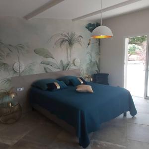 een slaapkamer met een groot blauw bed met blauwe lakens bij Villa Nais B&B in Bormes-les-Mimosas