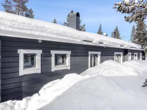 ein schneebedecktes Haus mit einem Schneehaufen in der Unterkunft Holiday Home Metso-pirtti by Interhome in Saariselkä