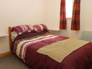 a bed with two pillows and a blanket in a bedroom at Daisy Nook in Hull