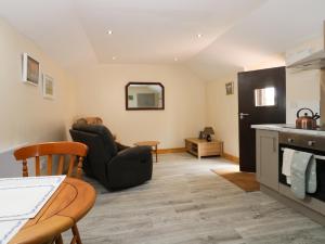 een woonkamer met een tafel en stoelen en een keuken bij Honeybee Cottage in Hull