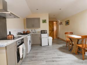 a kitchen with white appliances and a table and chairs at Honeybee Cottage in Hull