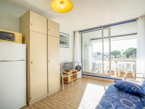 eine Küche mit einem Kühlschrank und ein Zimmer mit einem Fenster in der Unterkunft Studio Floralies I-4 by Interhome in Le Grau-du-Roi