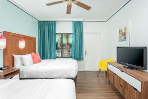 a bedroom with a bed and a television at Beachside Hotel and Suites in Cocoa Beach