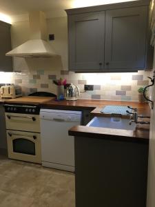 a kitchen with a sink and a stove top oven at 9 Melinda Cottage in Cromer