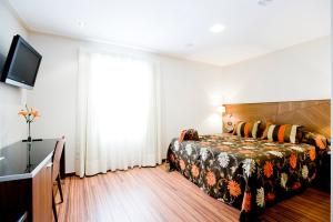 - une chambre avec un lit et une grande fenêtre dans l'établissement Hotel El Churra, à Murcie