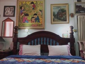 um quarto com uma cama e um quadro na parede em King's Home Hua Hin Homestay em Hua Hin