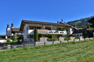 a house with a fence in front of a field at Appartment Bichler in Hopfgarten im Brixental