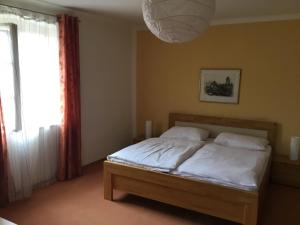 a bedroom with a bed with white sheets and a window at Pension Altes Rathaus in Dürnstein