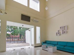 a living room with a blue couch and a tv at OYO 2753 Irma's Residence in Blitar
