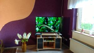 ein Wohnzimmer mit einem Fischaquarium in einer lila Wand in der Unterkunft Ferienwohnung Wolf in Greven